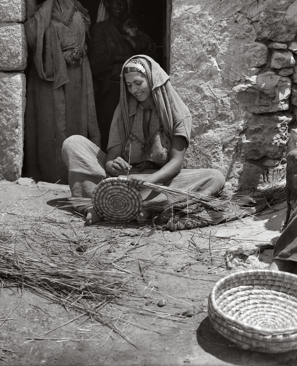 Женщина плетет корзину из тростника. Вифлеем, Палестина. 1898-1946 гг.
